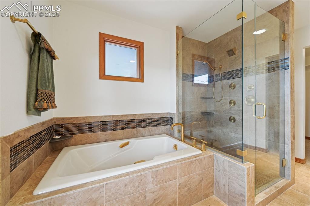 17580 Chipped Arrow Way Monument, CO 80132 - Photo 32 of 50 a bathroom with a tub a sink and glass door shower