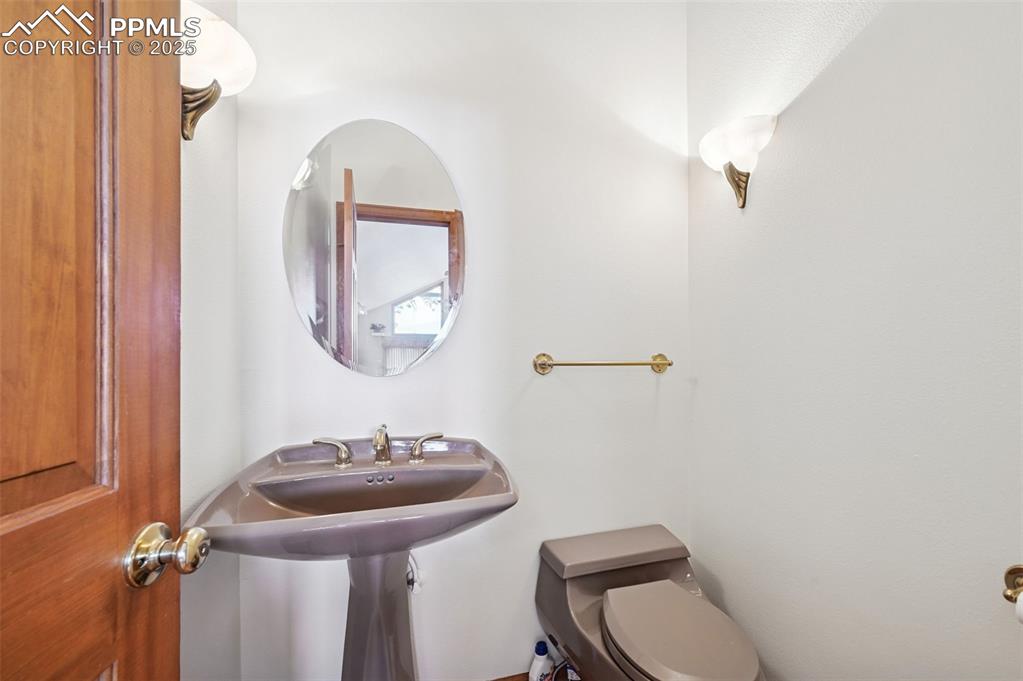 17580 Chipped Arrow Way Monument, CO 80132 - Photo 36 of 50 a bathroom with a toilet a sink and mirror