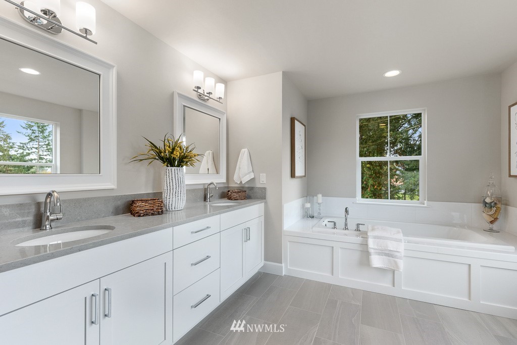 19037 85th ( 4) Avenue Bothell, WA 98011 - Photo 17 of 30 a bathroom with a double vanity sink a large mirror a bathtub and window