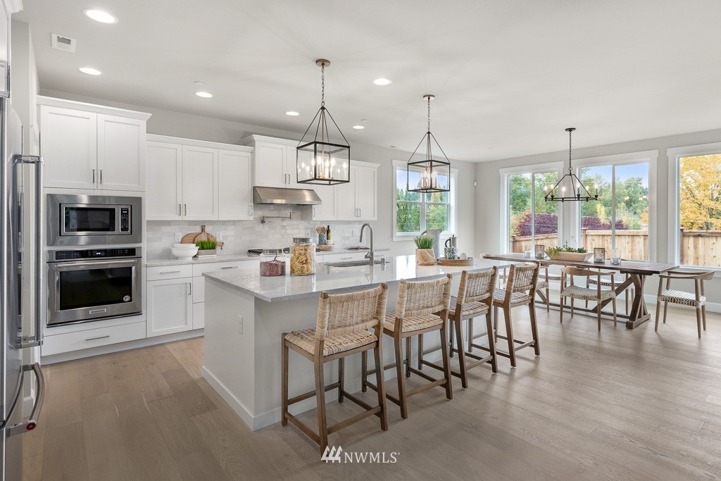 19037 85th ( 4) Avenue Bothell, WA 98011 - Photo 4 of 30 a kitchen with stainless steel appliances granite countertop a stove a refrigerator a kitchen island a dining table and chairs