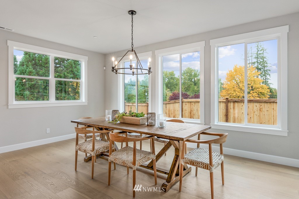 19037 85th ( 4) Avenue Bothell, WA 98011 - Photo 7 of 30 a view of a dining room with furniture large windows and wooden floor