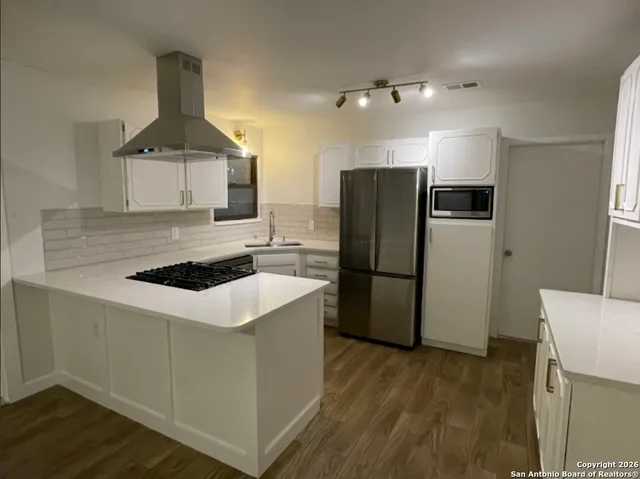 a kitchen with stainless steel appliances a stove a refrigerator and a sink