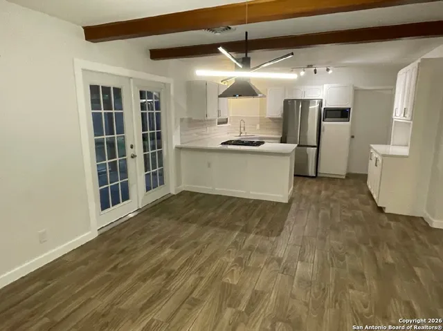 an empty room with windows and fan