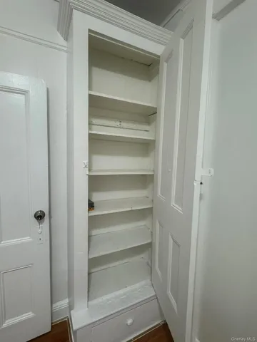 a view of walk in closet with empty racks
