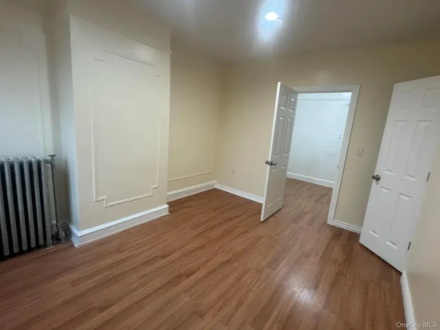 an empty room with wooden floor and a fireplace