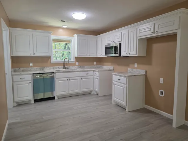 a kitchen with a sink cabinets and wooden floor