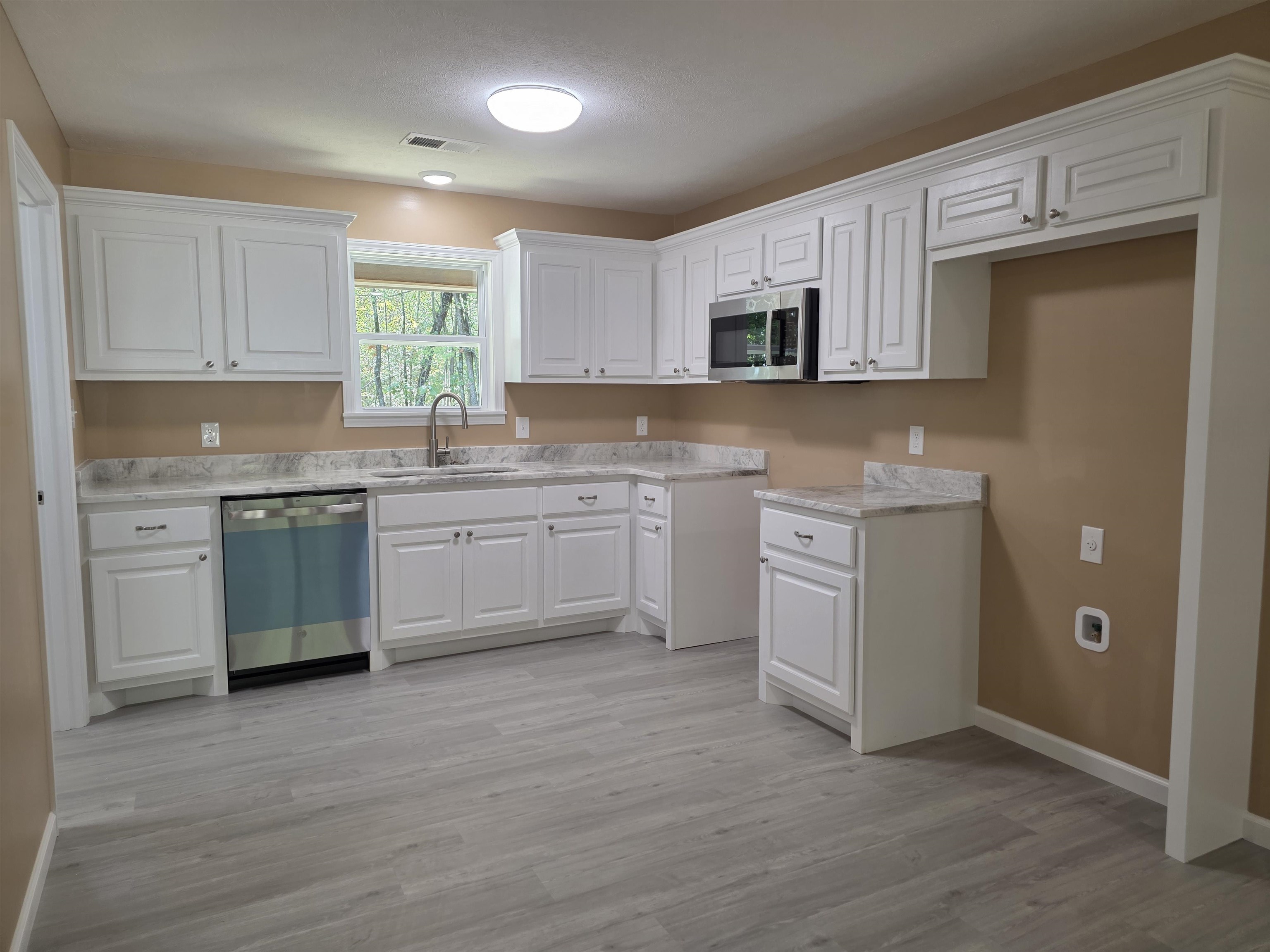 1020 Jade Road Savannah, TN 38372 - Photo 2 of 16 a kitchen with a sink cabinets and wooden floor
