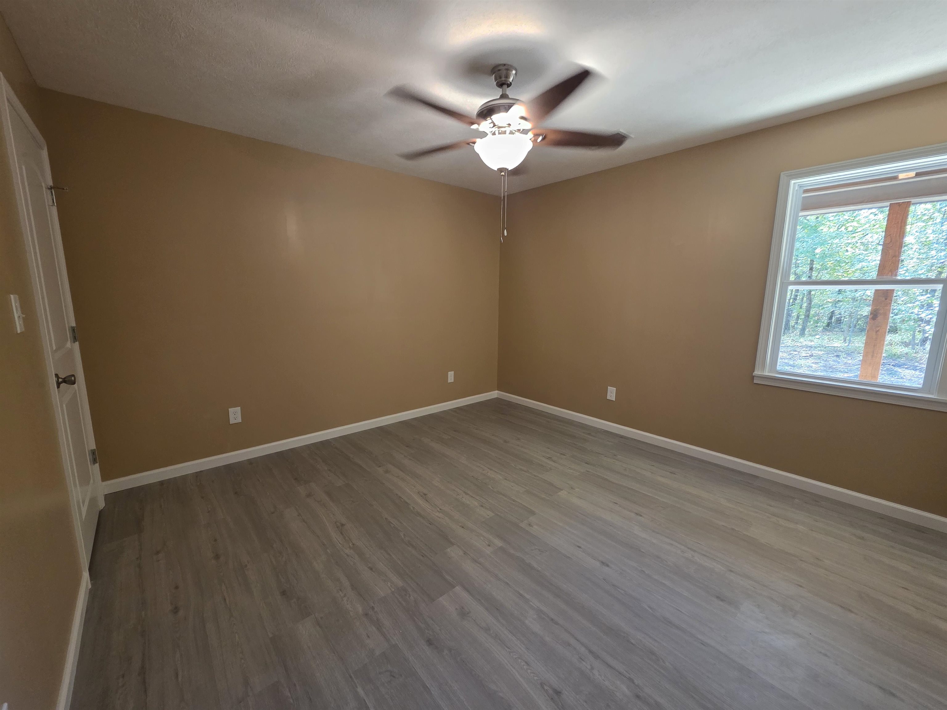1020 Jade Road Savannah, TN 38372 - Photo 7 of 16 an empty room with wooden floor and windows
