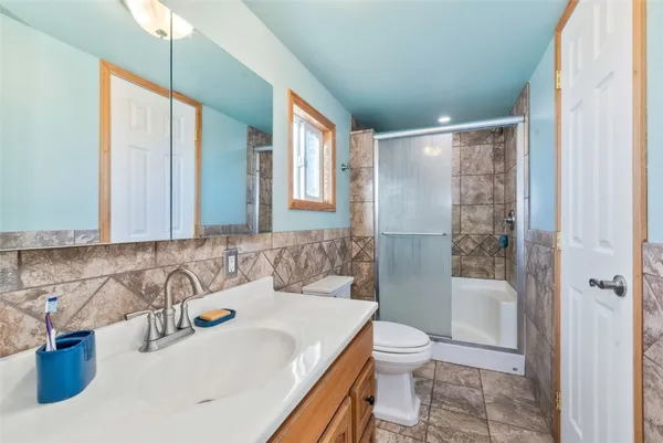 a bathroom with a sink a toilet and shower