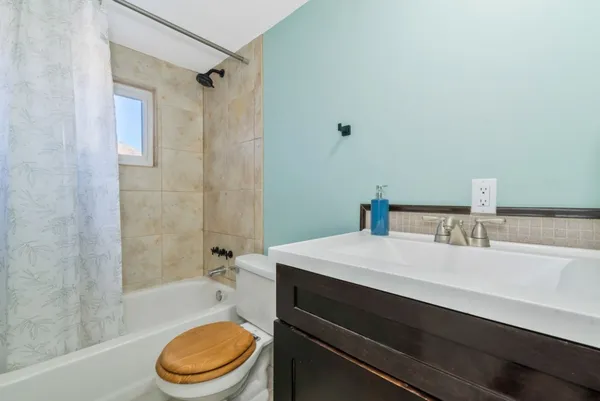 a bathroom with a granite countertop sink a toilet and a mirror