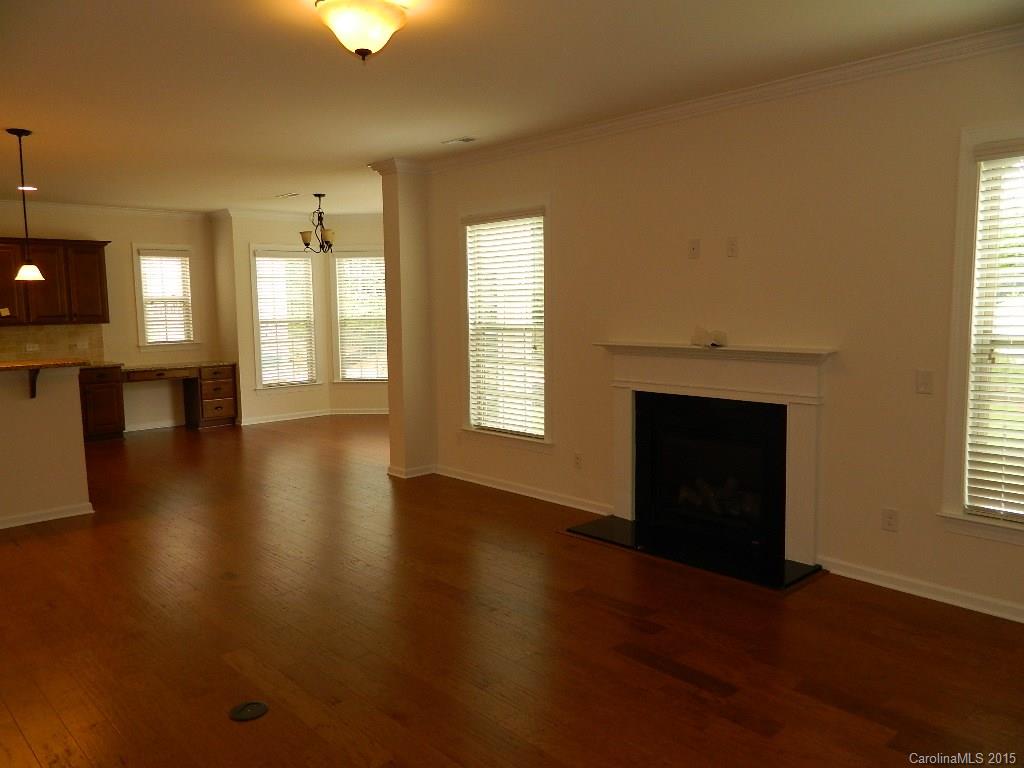574 Brookhaven Drive, Unit HKC90 Fort Mill, SC 29708 - Photo 6 of 7 an empty room with wooden floor fireplace and windows