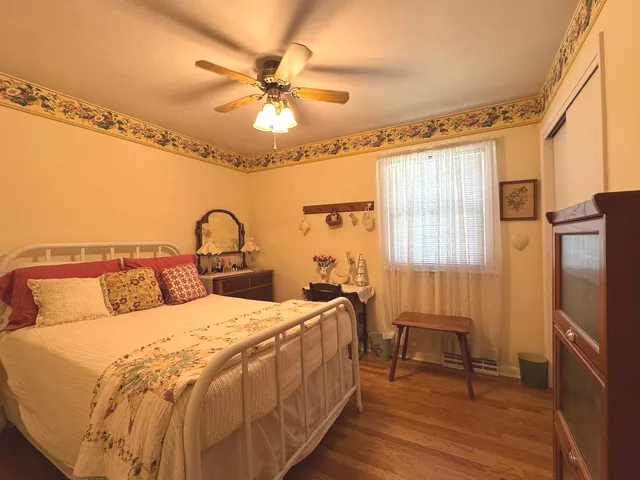 a bedroom with a bed a chandelier and a dresser