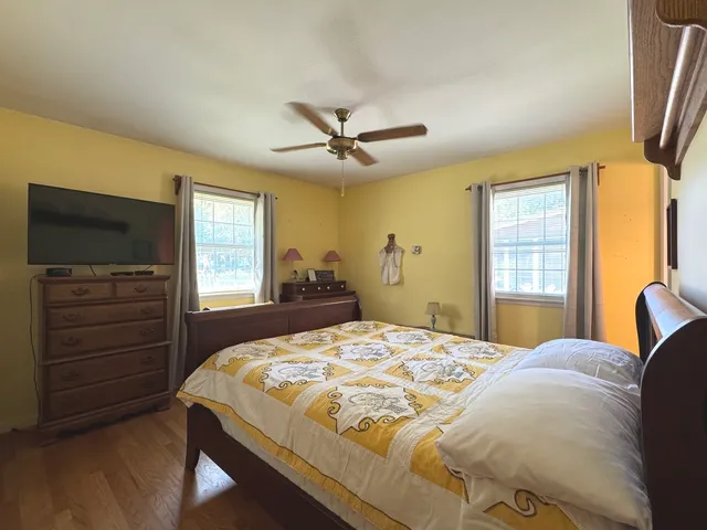 a bedroom with a bed and a flat tv screen on dresser