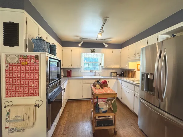 a kitchen with refrigerator cabinets and wooden floor