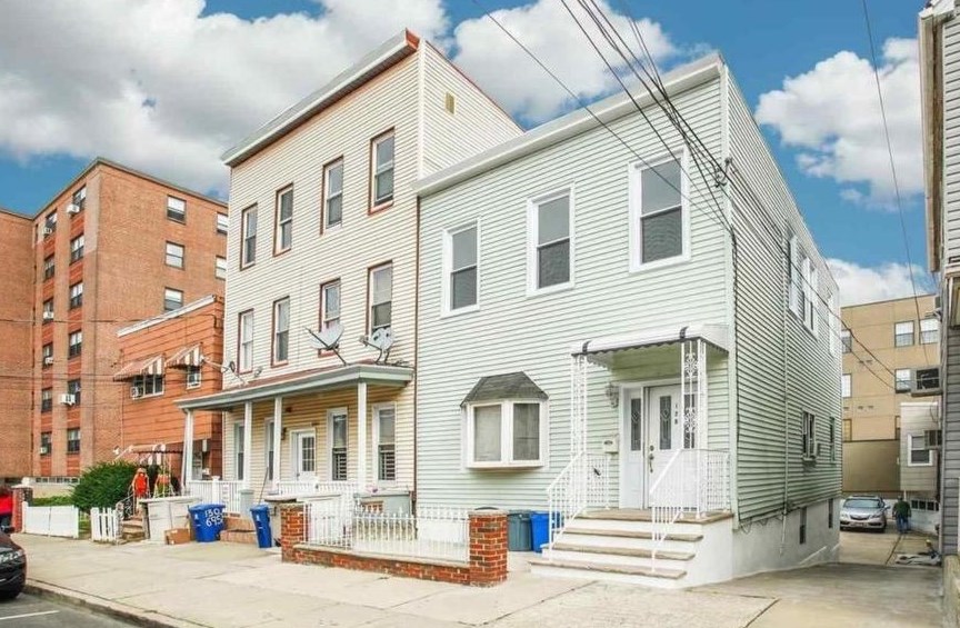a front view of a residential apartment building with a yard