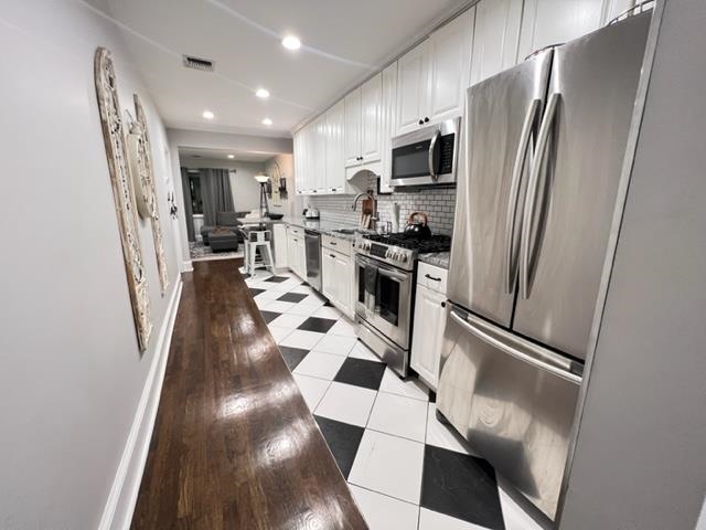 128 69th Street, Unit 1 Guttenberg, NJ 07093 - Photo 6 of 14 a kitchen with stainless steel appliances a refrigerator sink and microwave