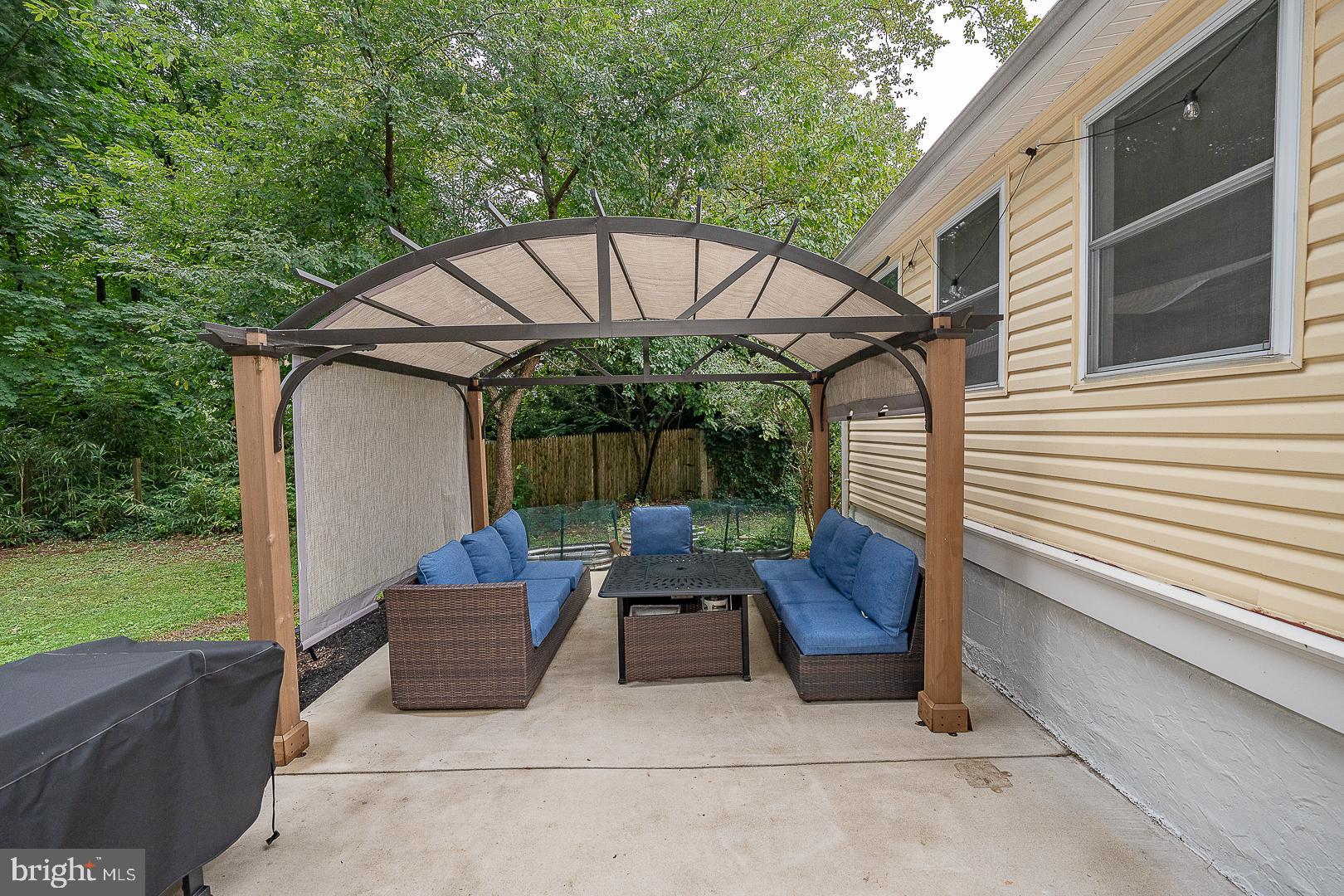 332 Old Lancaster Road Devon, PA 19333 - Photo 24 of 28 a view of a patio with table and chairs under an umbrella with a small yard