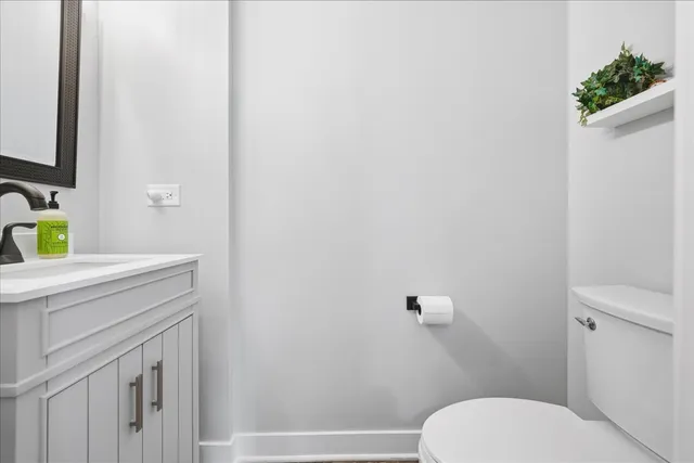 a bathroom with a granite countertop toilet and a sink