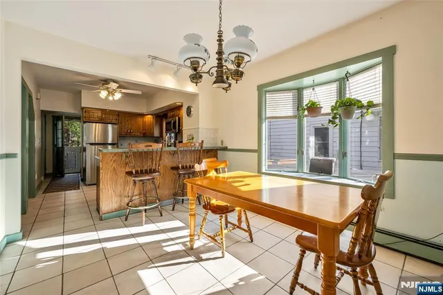 a view of a dining room with furniture a chandelier and window