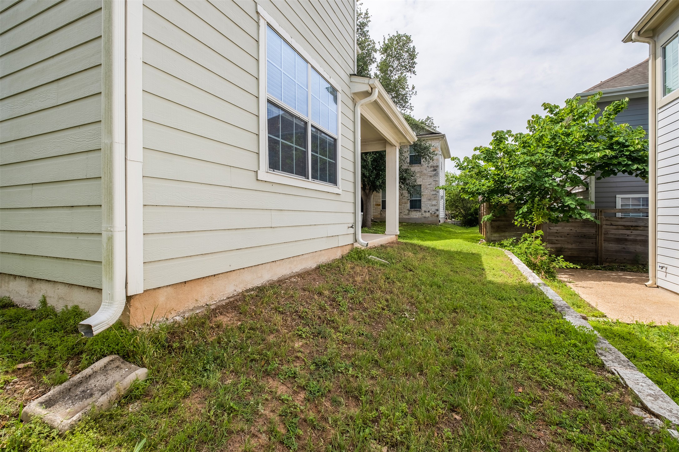 6715 Windrift Way, Unit 8 Austin, TX 78745 - Photo 24 of 24 A well-maintained side yard with verdant grass borders a home with classic siding.