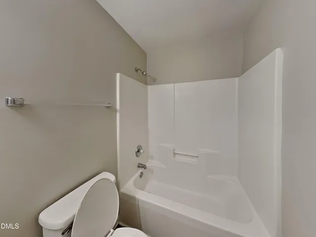 a white toilet sitting next to a bath tub