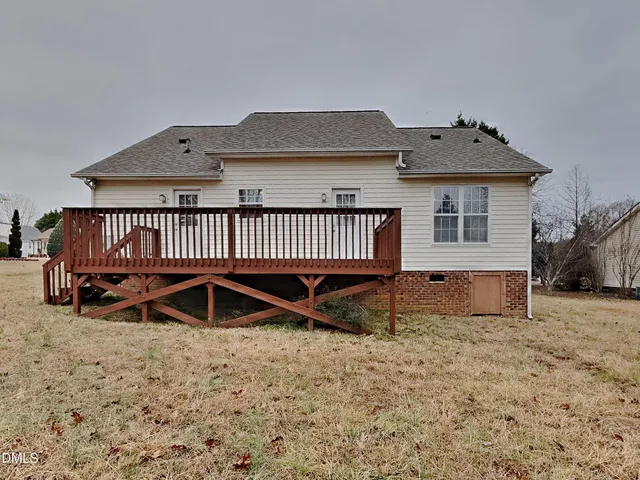 a view of a house with a yard and deck