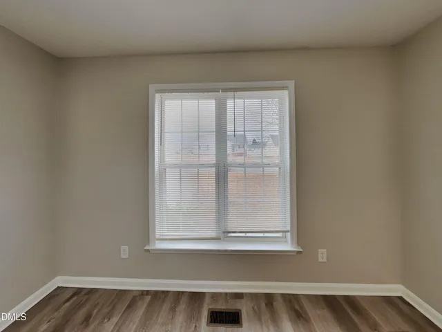 a view of a small space with wooden floor and a window