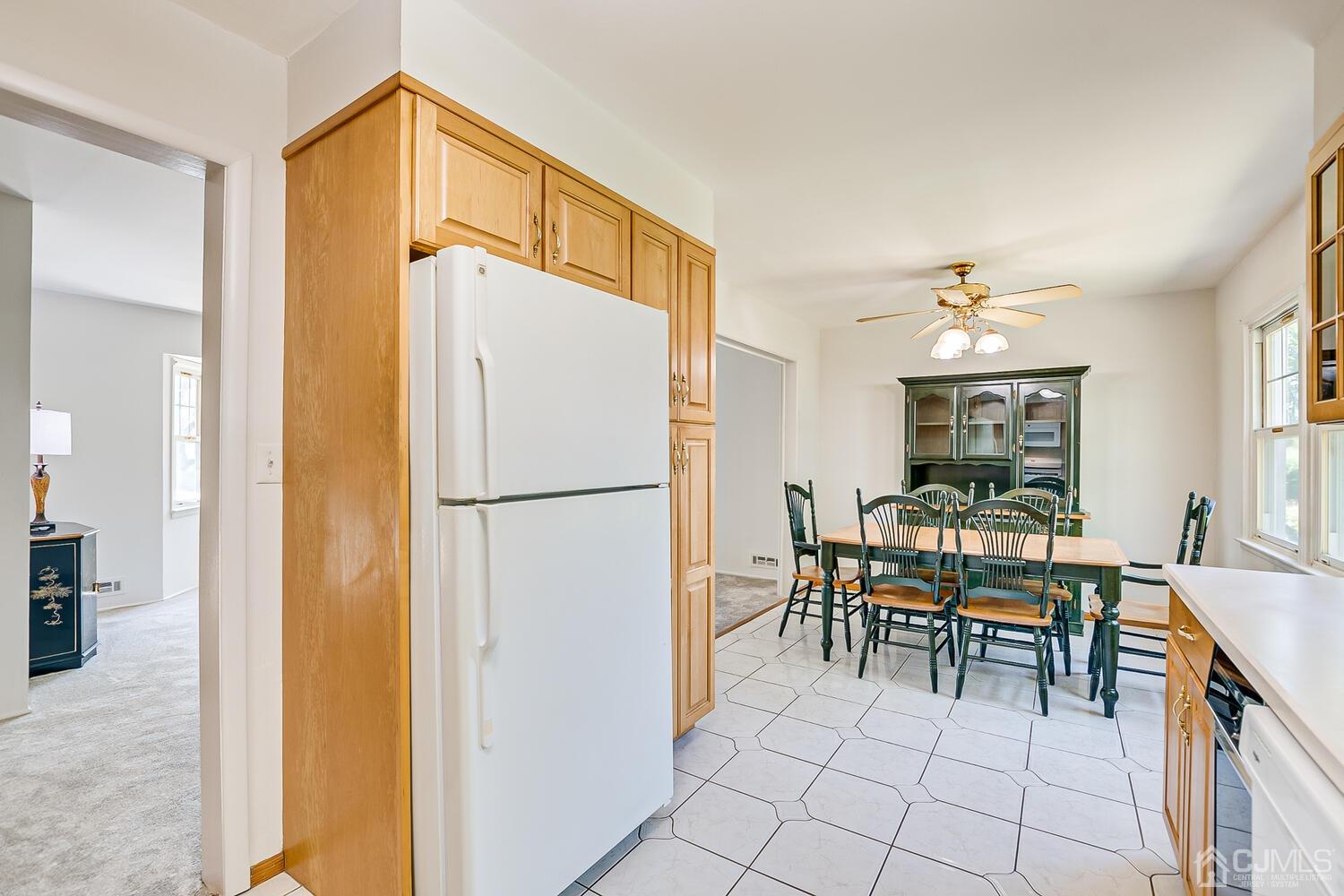 8 Meyer Road Edison, NJ 08817 - Photo 24 of 47 a dining room with furniture a chandelier and a refrigerator