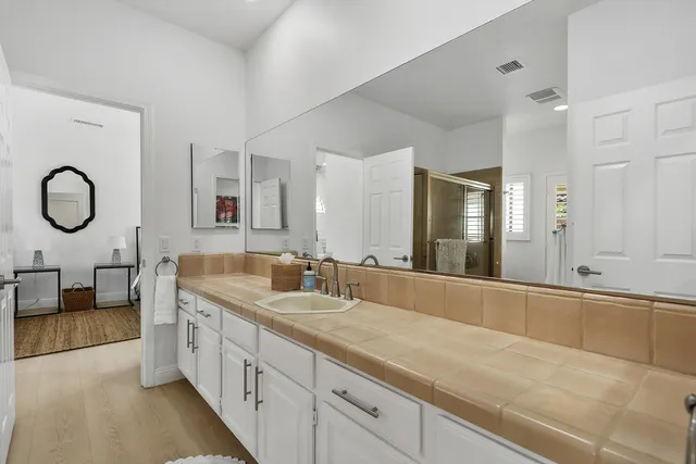 a spacious bathroom with a double vanity sink and a mirror