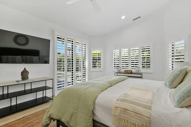 a bedroom with a bed and a large window