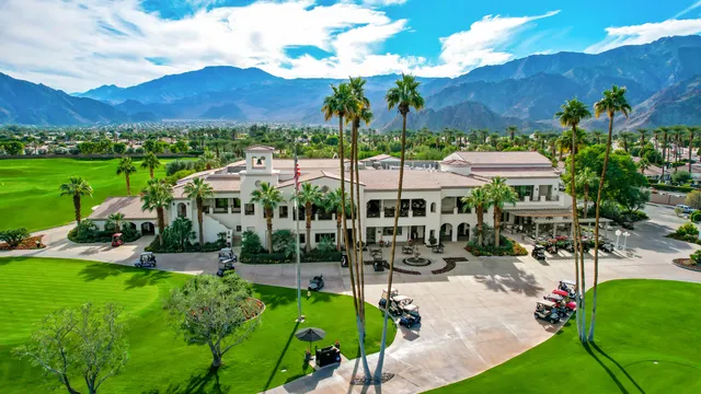 a view of a lush green field with mountains in the background
