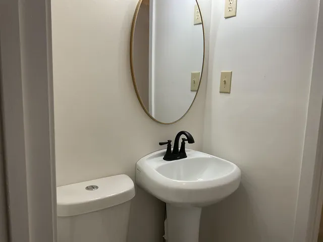 a bathroom with a sink a toilet and a mirror