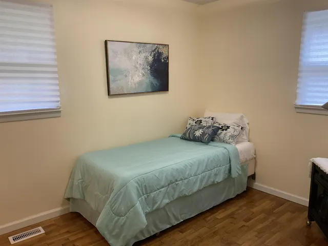 a bedroom with a bed and wooden floor