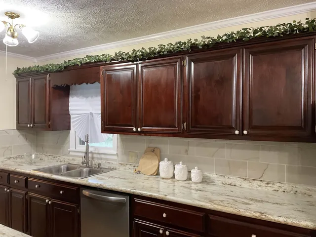 a kitchen with granite countertop a sink and cabinets
