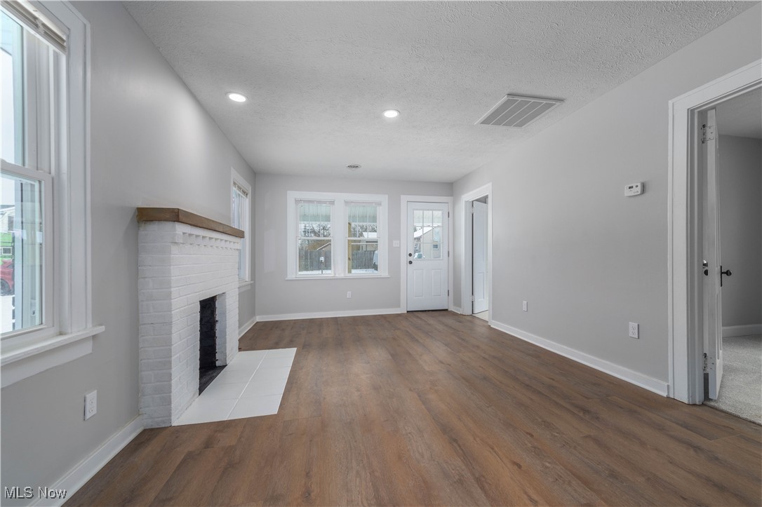 218 Roxboro Road Vermilion, OH 44089 - Photo 7 of 50 Unfurnished living room with a fireplace, wood finished floors, a textured ceiling, and recessed lighting