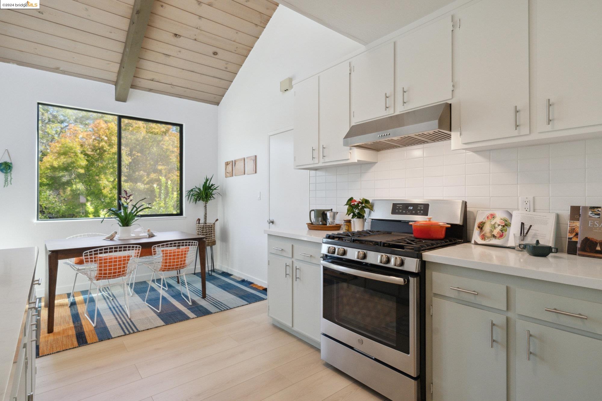 a kitchen with stainless steel appliances granite countertop a stove a sink dishwasher and cabinets with wooden floor