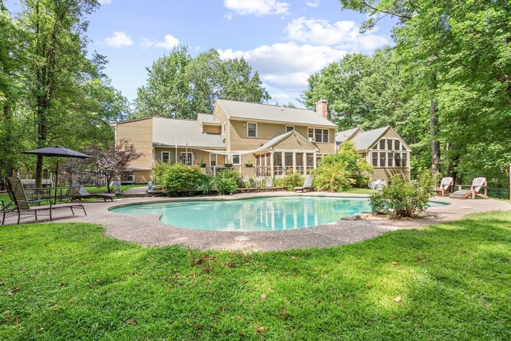 a view of a house with a patio and a yard