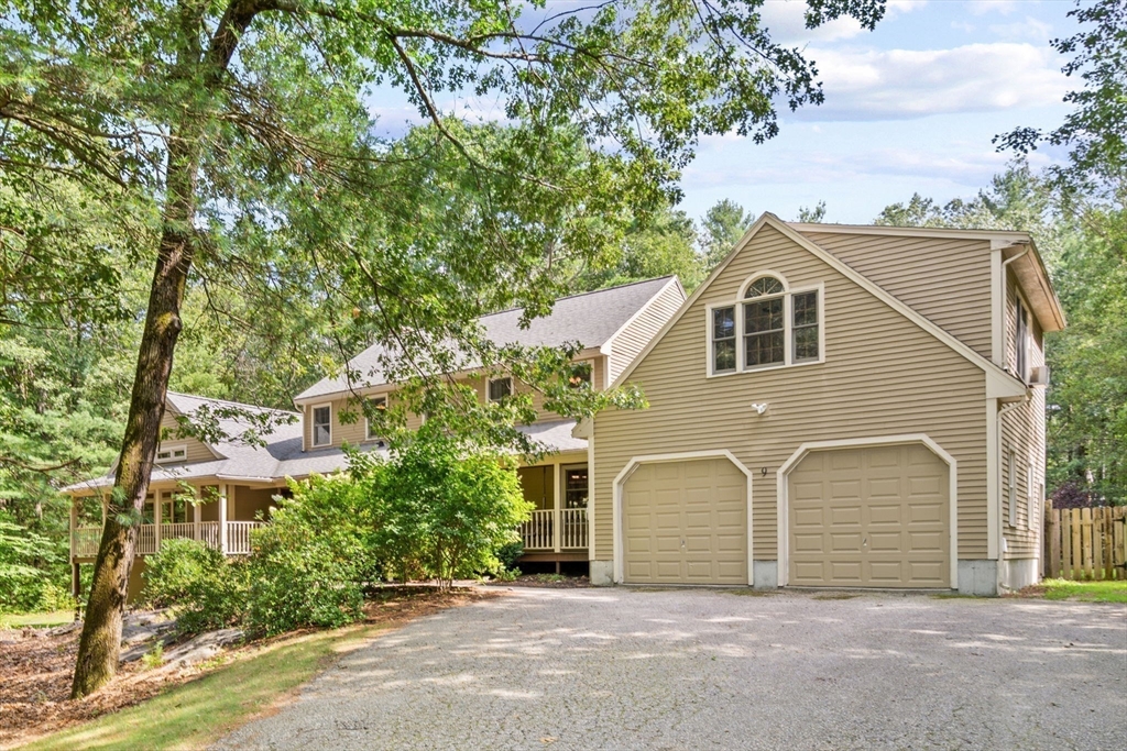 9 Stagecoach Road Princeton, MA 01541 - Photo 29 of 42 a view of a grey house with large windows and a large tree