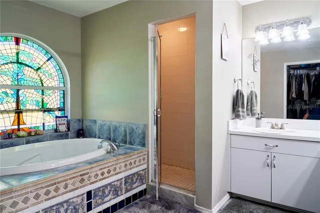 a spacious bathroom with a tub a sink and a large mirror