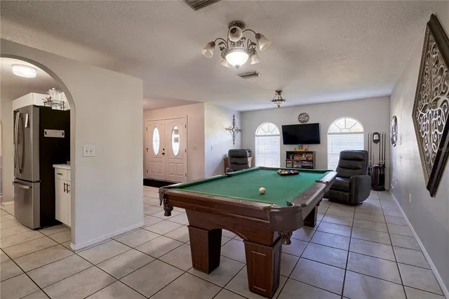 a room with pool table and windows