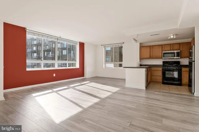 a view of a kitchen with wooden floor and a window