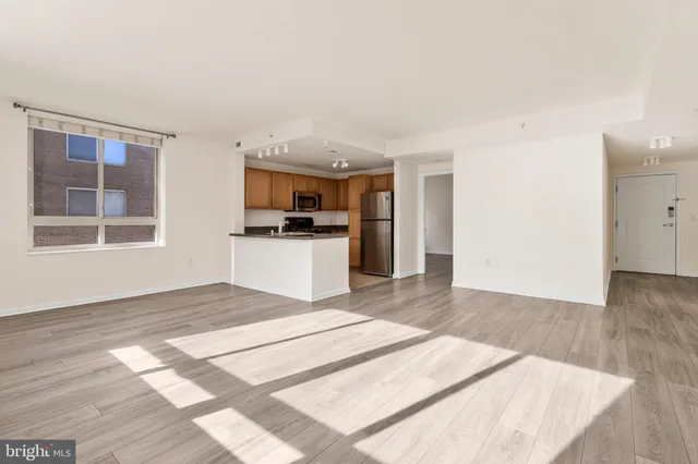 a view of a kitchen with a sink a kitchen and an empty room