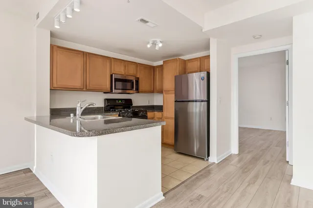 a kitchen with stainless steel appliances granite countertop a refrigerator stove a sink and a microwave