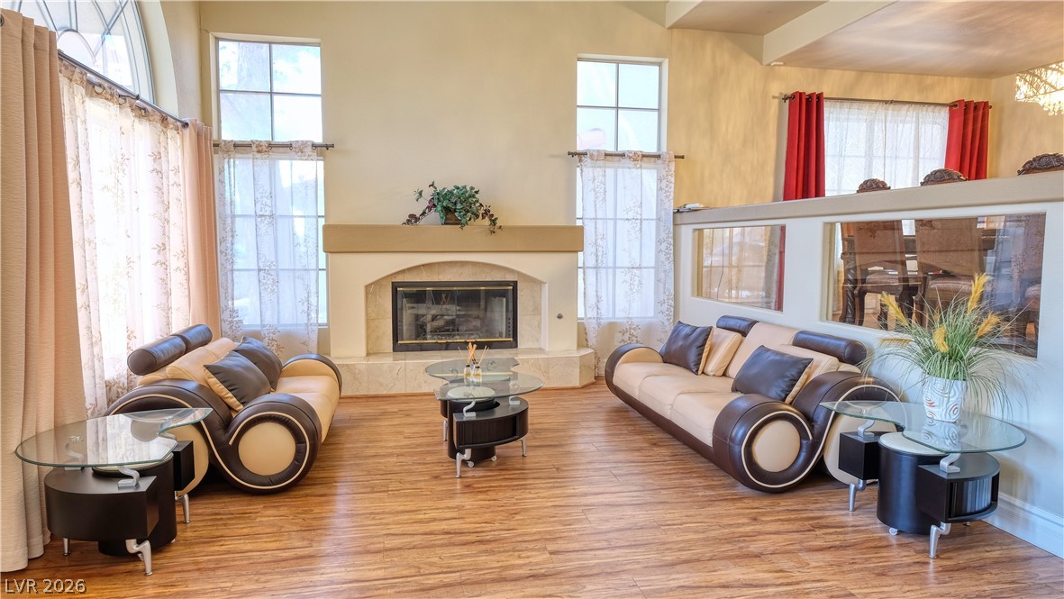 3704 North Campbell Road Las Vegas, NV 89129 - Photo 2 of 38 A striking fireplace anchors this generous living area with light-filled windows and rich wood flooring.