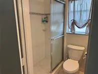 a white toilet sitting next to a shower