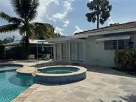 a view of house with swimming pool and a yard