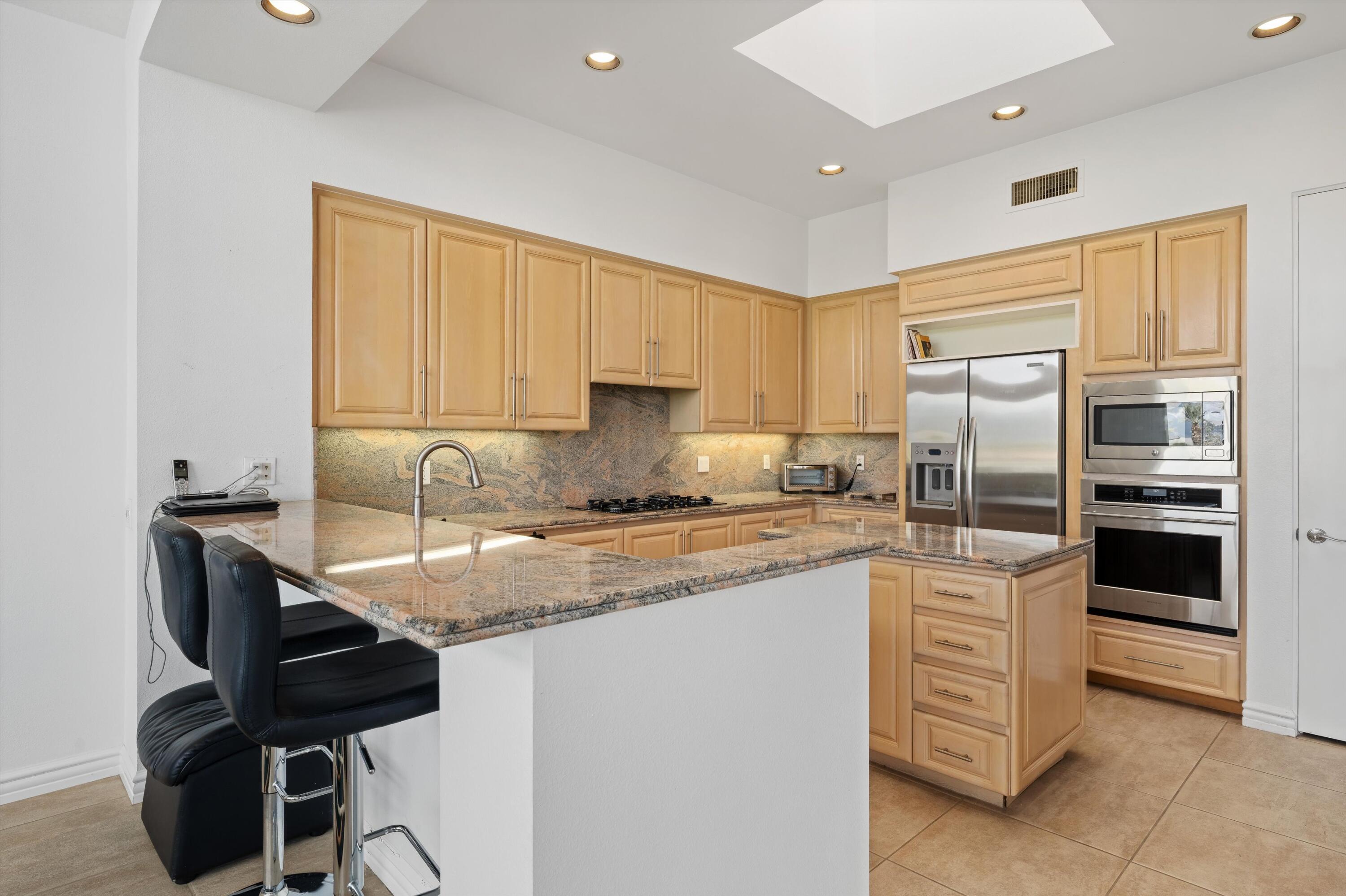 870 Deer Haven Circle Palm Desert, CA 92211 - Photo 18 of 37 a kitchen with stainless steel appliances granite countertop a sink stove and refrigerator