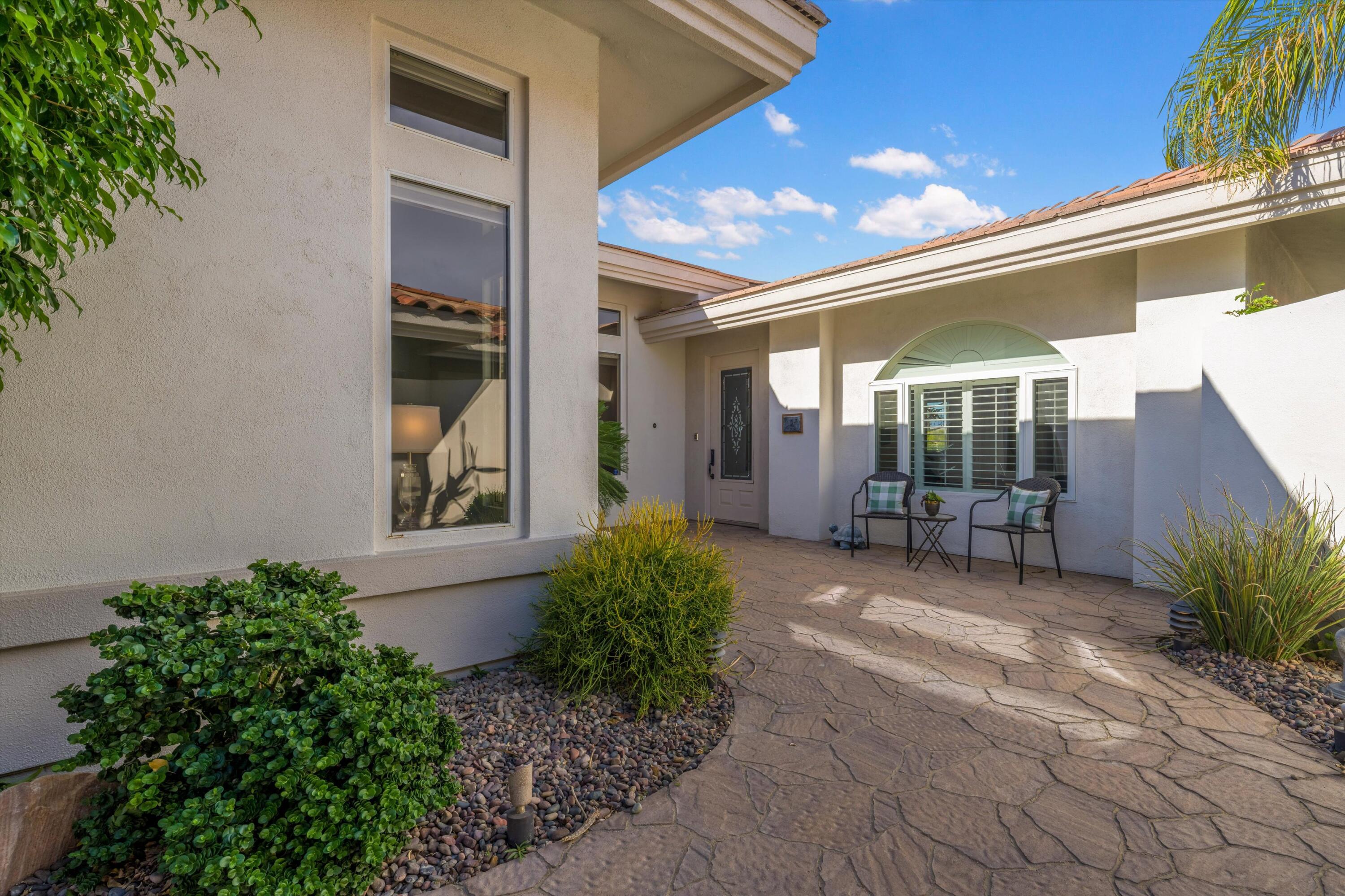 870 Deer Haven Circle Palm Desert, CA 92211 - Photo 6 of 37 a view of a house with a large window and potted plants