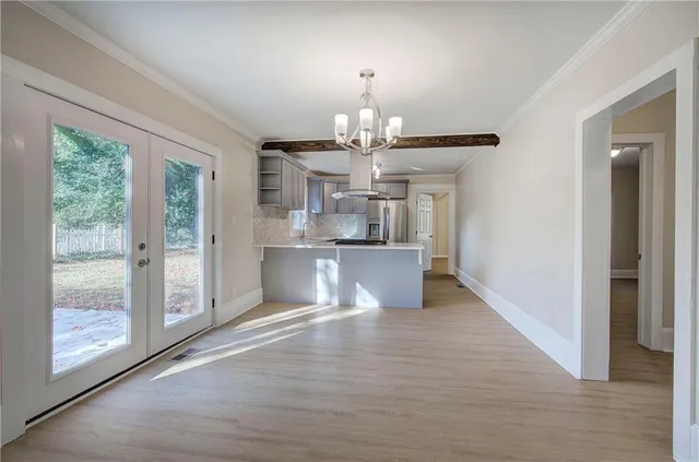 a view of a dining room with wooden floor a chandelier