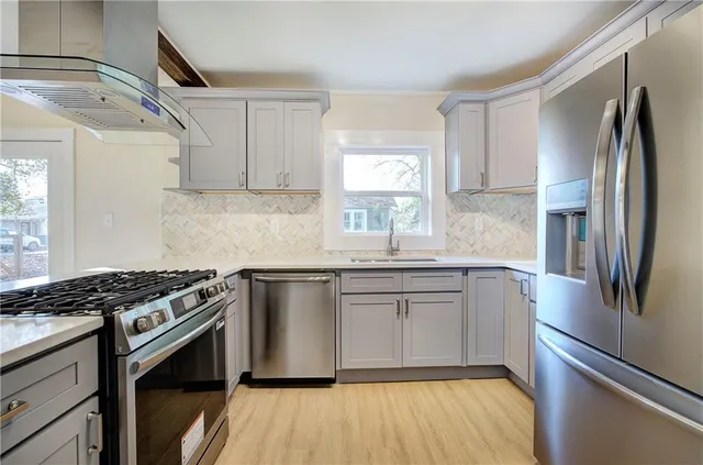a kitchen with stainless steel appliances granite countertop a sink stove and refrigerator
